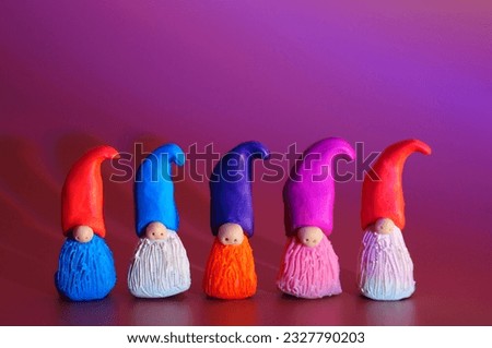 Figurines of colorful dwarfs made of plasticine. Color background.