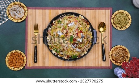 Sweet dish or sweet rice pakistani dish served with almonds, coconut and cabin on a green mat 