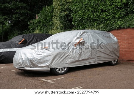 Vehicle under protective cover in parking space Royalty-Free Stock Photo #2327794799