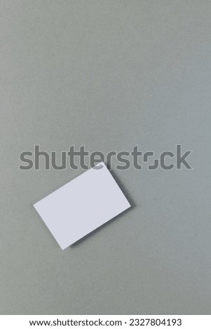 Vertical image of white business card with copy space on grey background. Business, business card, stationery and writing space concept.