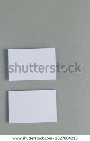 Vertical image of white business cards with copy space on grey background. Business, business card, stationery and writing space concept.