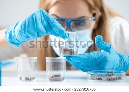 Scientist holds fecal transplant caps in the lab. Witness the forefront of research aimed at revolutionizing healthcare and improving lives Royalty-Free Stock Photo #2327810785