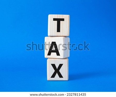 Tax symbol. Wooden cubes with word Tax. Beautiful blue background. Business and Finace and Tax concept. Copy space.