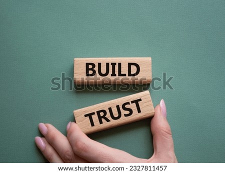 Build trust symbol. Wooden blocks with words Build trust. Beautiful grey green background. Businessman hand. Business and Build trust concept. Copy space.
