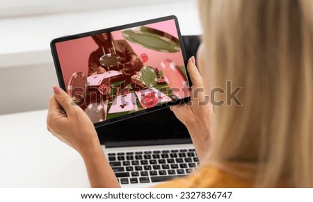 Close up cropped shot of male hands making bets using gambling mobile application on his phone. Man watching football match online broadcast on his laptop waiting for winning results.