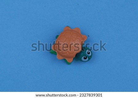 children's toy turtle isolated on blue background