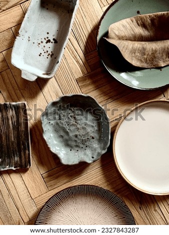 Handmade round brown and green plates on wooden table in flat lay photography