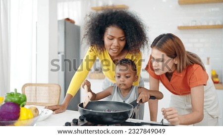 Happy homosexual lesbian couple and american african adopted child enjoy cooking in kitchen room at home. Lesbian marriage and adoption. Homosexual family, LGBTQ lifestyle Royalty-Free Stock Photo #2327849049