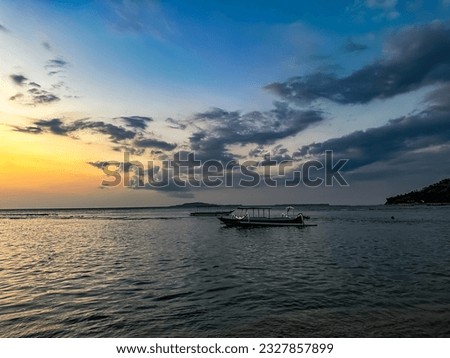 Horizontal sunset view of traditional Indonesian outriggers fishing boat on the sea