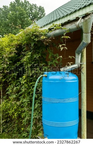 water collection tank under a roof with a drain. Rain water harvesting architecture. Vertical photo. reuse concept Royalty-Free Stock Photo #2327862267