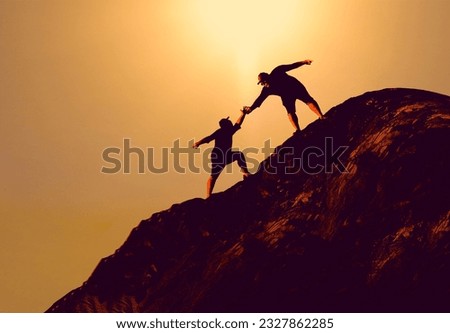 silhouette of People helping each other hike up a mountain at sunrise. Giving a helping hand, and active fit lifestyle concept. Male hikers climbing up mountain cliff. team work concept. Royalty-Free Stock Photo #2327862285