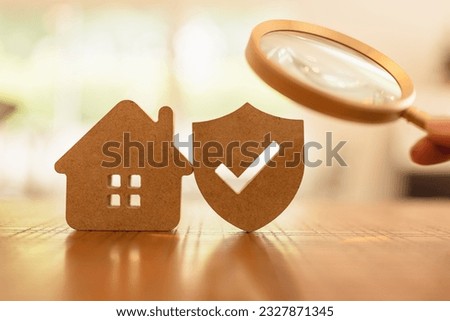 Hand holding magnifying glass and looking at house and shield protect icon, The concept of finding the right insurance for the right lifestyle of each person, health insurance, home, car, savings.	