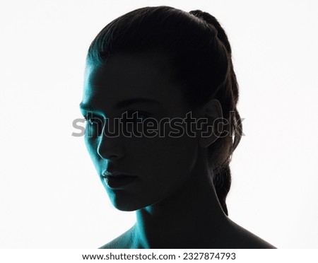 Beauty, woman and neon shadow light with dark lighting or posing in studio or skincare glow. Aesthetic, creativity and silhouette or face of a young model with blue color design on background