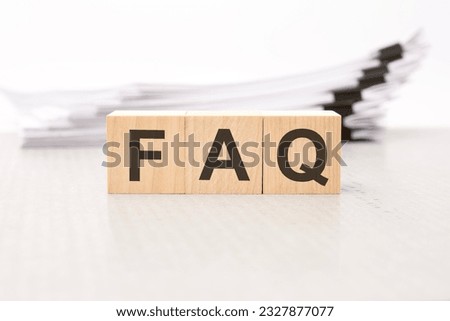 FAQ letters on wooden cubes. the background is a white business papers. finance concept