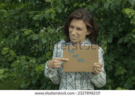The woman is holding a poster that says - you have it. Soft selective focus.