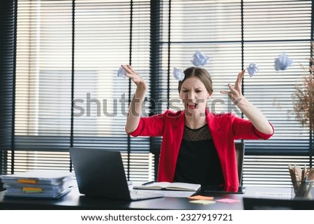 A stressed and frustrated businesswoman is seen sitting at her desk, shouting at her laptop in anger due to a mistake or crisis in the business
