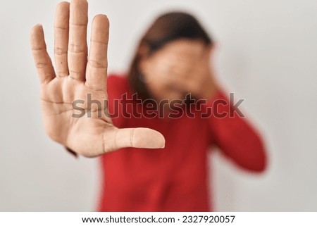 Hispanic mature woman standing over white background covering eyes with hands and doing stop gesture with sad and fear expression. embarrassed and negative concept. 