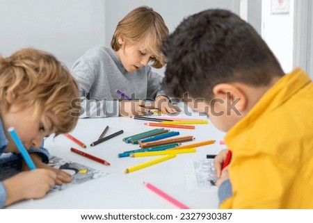 Children drawing paint with colorful pencils coloring book in educational class at school. Art creative lessons developing imagination fine motor skills Royalty-Free Stock Photo #2327930387