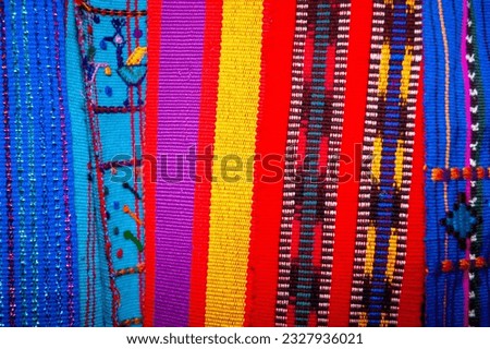 Colorful textile for sale in public space in Guatemala City, work done by indigenous hands of millenary Mayan culture, handicraft work economy in Latin America. Royalty-Free Stock Photo #2327936021