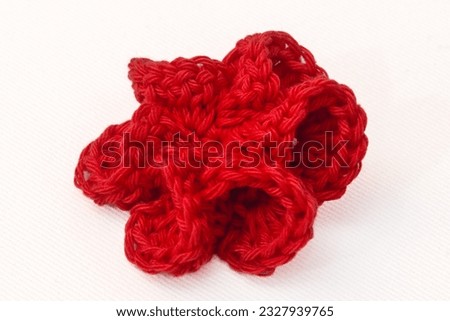 Colorful flower knitted with crochet, as hair clips, on a white background, isolated