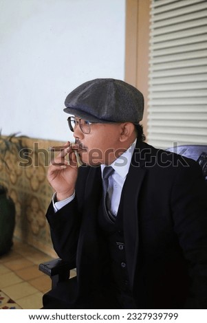 Cirebon, Indonesia - April 07, 2023 : a man holding a cigar