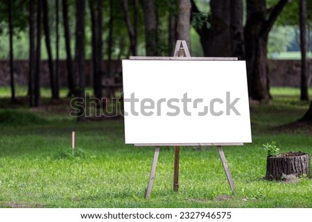 Wooden easel with blank canvas in park, mockup