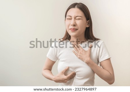 Acid reflux disease, suffer asian young woman have symptom gastroesophageal, esophageal, stomach ache and heartburn pain hand on chest from digestion problem after eat food, Healthcare medical concept Royalty-Free Stock Photo #2327964897