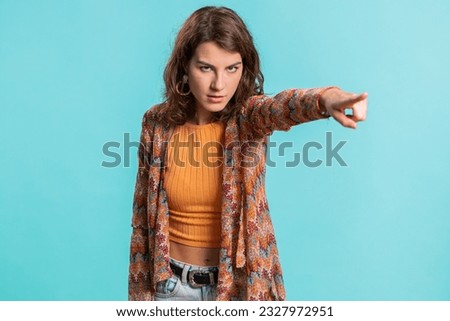 Get out of here. You are fired. Young Caucasian woman pointing finger away asking to leave her alone, strict boss firing, conflict, quarrel. Brunette girl isolated on blue studio background indoors Royalty-Free Stock Photo #2327972951
