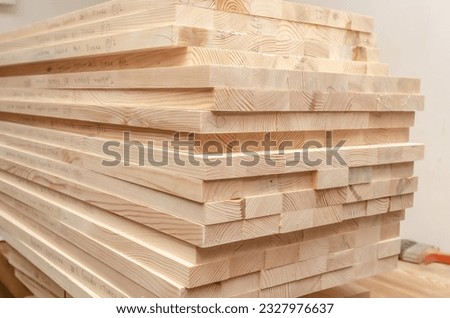 Sawn wooden boards stacked in production workshop. Carpenter.