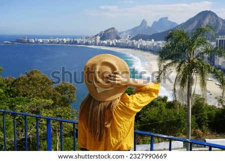 Holidays in Rio de Janeiro. Back view of tourist girl enjoying view of Copacabana beach from viewpoint in Rio de Janeiro, Brazil. Royalty-Free Stock Photo #2327990669