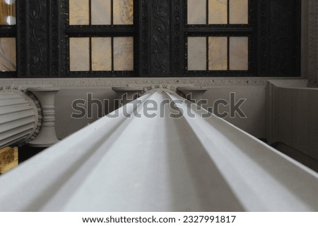 A close up photo of the details of a white pillar. 