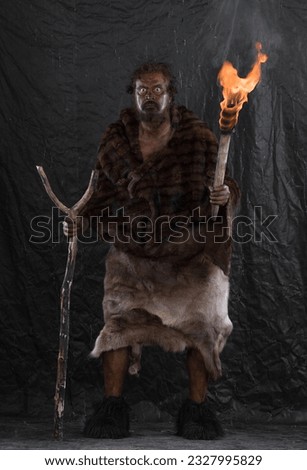 portrait of a caveman with a torch Royalty-Free Stock Photo #2327995829