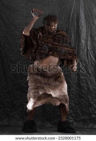 portrait of a caveman with a stone,neanderthal Royalty-Free Stock Photo #2328001175