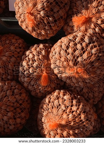 Orange mesh bags with hazelnuts lie on the counter at the grocery market