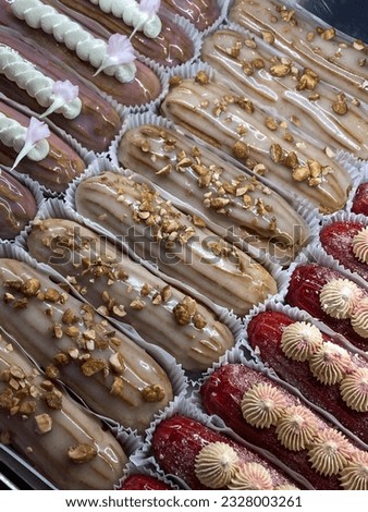 Different types of eclairs with cream are seen on the counter in a cafe