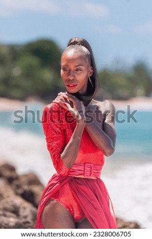 Portrait of Beautiful Caribbean Adult Teen in Barbados. Wearing Red Bikini on a tropical beach. Caribbean Sea in Background. Black. Portrait.
