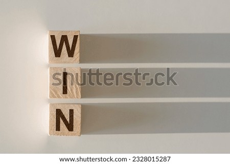 WIN word written on wood block. WIN text on light table for your desing, concept.