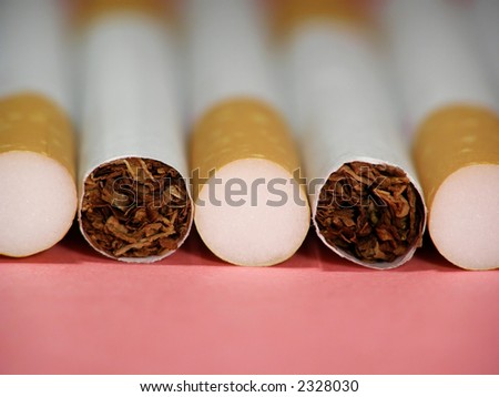 Close-up of cigarettes with filter against a red background