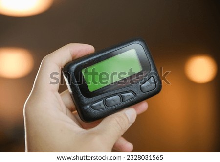 pager beeper lies on a desk, symbolizing instant communication and connection, bridging distances and enabling efficient messaging in the digital age Royalty-Free Stock Photo #2328031565