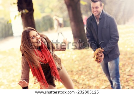 A picture of a happy couple having fun in the park in autumn