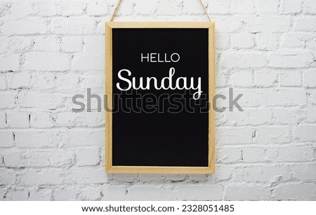 Happy Sunday typography text on blackboard hanging against on the wall background