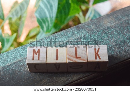 Sentences in English "MILK" with the media of wooden boxes arranged into a word