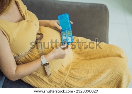 Prenatal Vitamins. Portrait Of Beautiful Smiling Pregnant Woman Holding Pill Box, Taking Supplements For Healthy Pregnancy While Sitting On Couch At Home, Free Space Royalty-Free Stock Photo #2328098029
