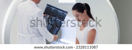 Portrait of practitioner looking at mri picture, female patient at medical consultation. Magnetic resonance imaging and diagnostic concept