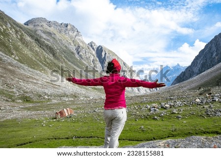 Young lady standing in front of the beautiful Hampta Valley of Himachal Pradesh, India. Royalty-Free Stock Photo #2328155881