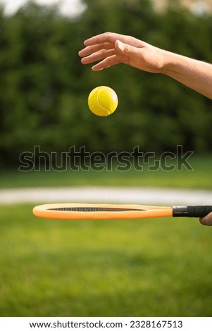 The man holds a tennis racket and a ball in her hands. Outdoor sports. Active lifestyle. Useful games.