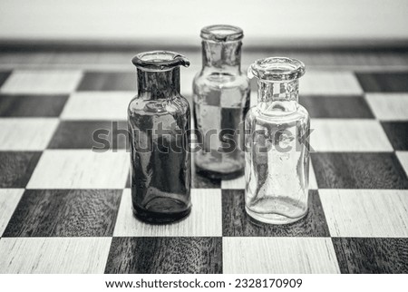 Arrangement of three bottles on a chess board.