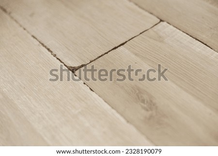 Swollen and dirty laminate floor, close up view. Moisture damage. Laminate flooring has swelled. Damaged laminate planks. Home, property insurance. Royalty-Free Stock Photo #2328190079