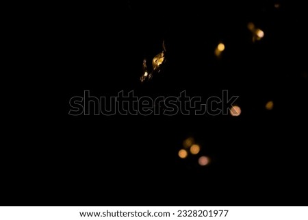 The close-up photograph of a night light is golden yellow with a bokeh background behind it