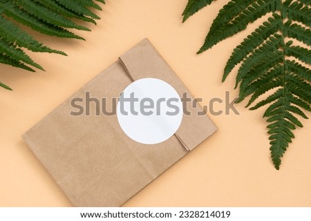 A mock-up of a round sticker on a gift craft package, an envelope with a blank sticker, an adhesive label on a colored background Royalty-Free Stock Photo #2328214019